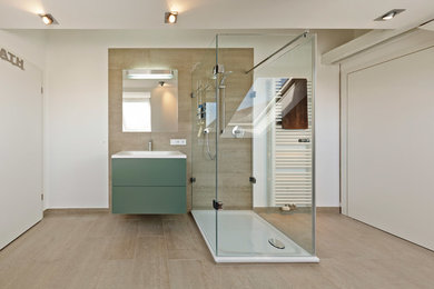 Großes Modernes Badezimmer mit flächenbündigen Schrankfronten, grünen Schränken, beigen Fliesen, Steinfliesen, weißer Wandfarbe und Einbauwaschbecken in Köln