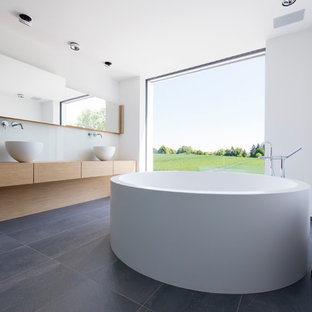 Ispirazione per una grande stanza da bagno padronale minimalista con ante lisce, ante in legno chiaro, vasca freestanding, pareti bianche, lavabo a bacinella, top in legno e top beige