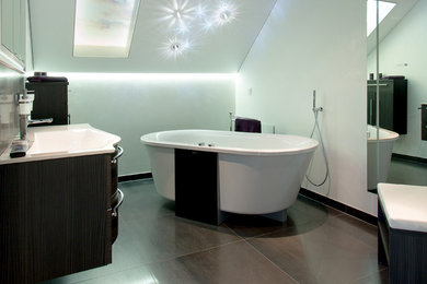 Ejemplo de cuarto de baño principal contemporáneo pequeño con armarios con paneles lisos, puertas de armario de madera en tonos medios, bañera exenta, paredes blancas, lavabo integrado y suelo marrón
