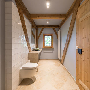 Kleines Uriges Duschbad mit Einbaubadewanne, bodengleicher Dusche, Wandtoilette, weißen Fliesen, Keramikfliesen, blauer Wandfarbe, Kalkstein, Aufsatzwaschbecken, Kalkstein-Waschbecken/Waschtisch, beigem Boden und offener Dusche in München
