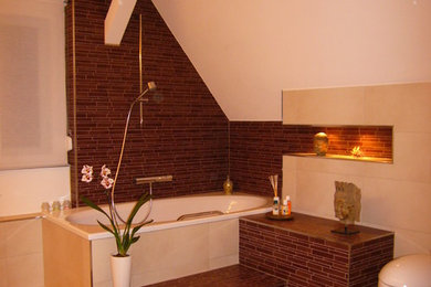 Ejemplo de cuarto de baño actual con bañera encastrada, sanitario de pared, baldosas y/o azulejos marrones, baldosas y/o azulejos en mosaico, paredes blancas, suelo de baldosas de cerámica y suelo beige