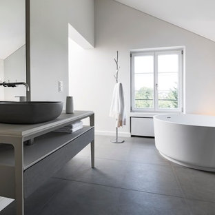 Inspiration för stora moderna beige en-suite badrum, med släta luckor, grå skåp, ett fristående badkar, en kantlös dusch, en toalettstol med separat cisternkåpa, beige kakel, kakelplattor, vita väggar, kalkstensgolv, ett fristående handfat, bänkskiva i kalksten, grått golv och dusch med skjutdörr