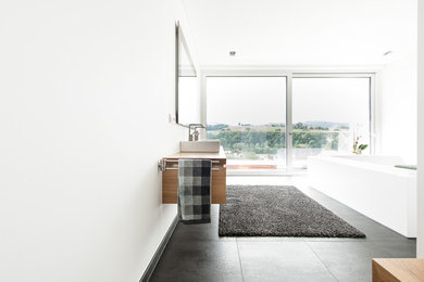 Großes Modernes Badezimmer mit hellbraunen Holzschränken, schwarzen Fliesen, weißer Wandfarbe, Aufsatzwaschbecken und Waschtisch aus Holz in Frankfurt am Main