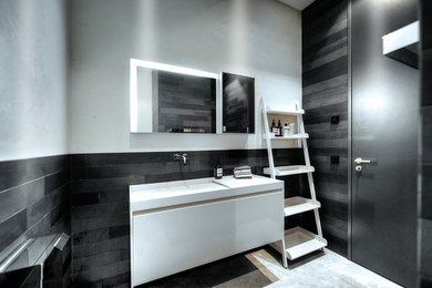 Imagen de cuarto de baño contemporáneo de tamaño medio con armarios con paneles lisos, puertas de armario blancas, baldosas y/o azulejos de piedra, paredes blancas y lavabo integrado