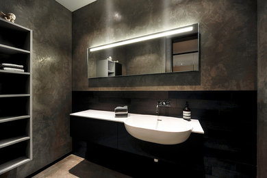 Ejemplo de cuarto de baño contemporáneo de tamaño medio con armarios con paneles lisos, puertas de armario negras, paredes marrones y lavabo encastrado