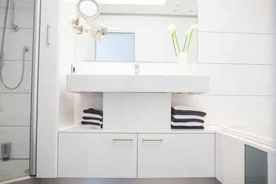 Modernes Badezimmer mit Einbaubadewanne, weißen Fliesen, weißer Wandfarbe, Keramikboden, Trogwaschbecken und grauem Boden in Düsseldorf