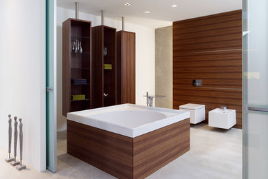 Großes Modernes Badezimmer mit offenen Schränken, dunklen Holzschränken, freistehender Badewanne, Bidet, weißer Wandfarbe und Betonboden in Düsseldorf