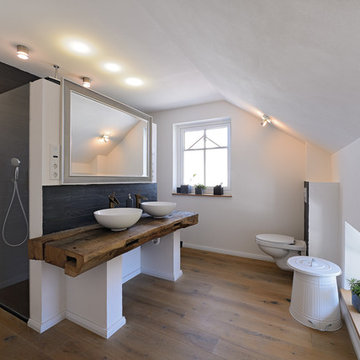 Badezimmer mit Altholz, Schieferfliesen und Holzboden