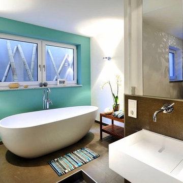 Badezimmer mit weißen Möbeln und türkiser Wand