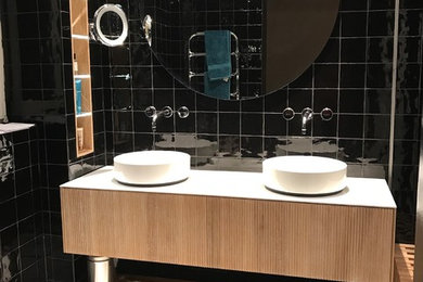 Modernes Badezimmer mit flächenbündigen Schrankfronten, hellen Holzschränken, schwarzen Fliesen, Keramikfliesen, Aufsatzwaschbecken, weißem Boden und weißer Waschtischplatte in Stuttgart