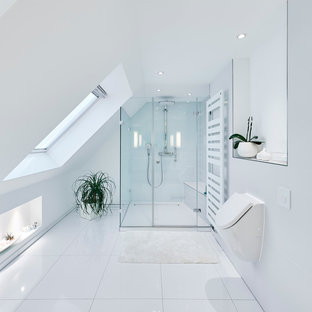 Foto di una stanza da bagno moderna di medie dimensioni con doccia a filo pavimento, orinatoio, piastrelle bianche, piastrelle in ceramica, pareti bianche e porta doccia a battente