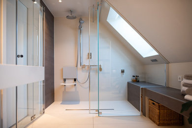 Modernes Badezimmer mit Wandtoilette mit Spülkasten, beigen Fliesen, grauer Wandfarbe, Waschtischkonsole, Waschtisch aus Holz, beigem Boden, Falttür-Duschabtrennung und weißer Waschtischplatte in Sonstige