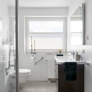 Mittelgroßes Modernes Duschbad mit flächenbündigen Schrankfronten, braunen Schränken, offener Dusche, Wandtoilette mit Spülkasten, weißen Fliesen, Keramikfliesen, weißer Wandfarbe, integriertem Waschbecken und braunem Boden in Sonstige