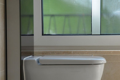 Kleines Modernes Duschbad mit weißen Schränken, Wandtoilette, weißen Fliesen, weißer Wandfarbe, Porzellan-Bodenfliesen, gefliestem Waschtisch, beigem Boden, weißer Waschtischplatte und Einzelwaschbecken in München