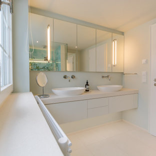 Mittelgroßes Modernes Duschbad mit blauen Fliesen, Keramikfliesen, beiger Wandfarbe, Keramikboden, Wandwaschbecken, beigem Boden, weißer Waschtischplatte, flächenbündigen Schrankfronten und weißen Schränken in München