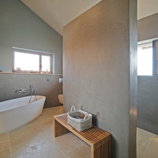 Mittelgroßes Modernes Badezimmer En Suite mit freistehender Badewanne, bodengleicher Dusche, grauer Wandfarbe, Travertin, beigem Boden, offener Dusche und Wandtoilette mit Spülkasten in München