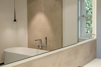 Modernes Badezimmer mit freistehender Badewanne, Mineralwerkstoff-Waschtisch und weißer Waschtischplatte in Sonstige