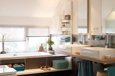Mittelgroßes Modernes Badezimmer mit Einbaubadewanne, Wandtoilette, schwarzen Fliesen, weißer Wandfarbe, Aufsatzwaschbecken und Waschtisch aus Holz in Hamburg