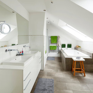 Großes Nordisches Duschbad mit flächenbündigen Schrankfronten, weißen Schränken, Einbaubadewanne, braunen Fliesen, weißen Fliesen, Einbauwaschbecken, grauem Boden und weißer Waschtischplatte in Bremen