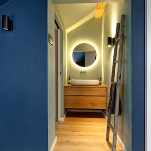 Mittelgroßes Modernes Duschbad mit flächenbündigen Schrankfronten, braunen Schränken, grüner Wandfarbe, hellem Holzboden, Aufsatzwaschbecken, Waschtisch aus Holz, beigem Boden und brauner Waschtischplatte in München