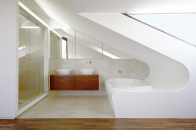 ミュンヘンにある高級な中くらいなコンテンポラリースタイルのおしゃれな浴室 (フラットパネル扉のキャビネット、茶色いキャビネット、ドロップイン型浴槽、ダブルシャワー、ベージュのタイル、セメントタイル、白い壁、ベッセル式洗面器、木製洗面台) の写真