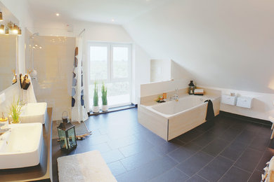 Skandinavische Sauna mit freistehender Badewanne, Wandtoilette, beigen Fliesen, Steinfliesen, weißer Wandfarbe, Aufsatzwaschbecken und Mineralwerkstoff-Waschtisch in Köln