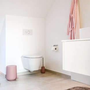 Mittelgroßes Modernes Duschbad mit Wandtoilette mit Spülkasten, Aufsatzwaschbecken, flächenbündigen Schrankfronten, weißen Schränken, weißen Fliesen, weißer Wandfarbe, Kalkstein, beigem Boden und weißer Waschtischplatte in Dortmund