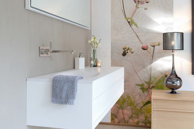 На фото: главная ванная комната среднего размера с плоскими фасадами, белыми фасадами, бежевыми стенами, полом из керамогранита, раковиной с пьедесталом и столешницей из искусственного камня с