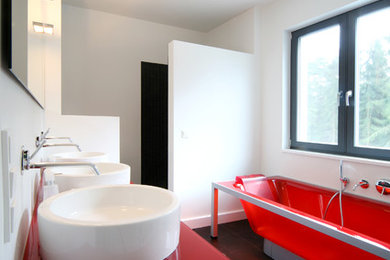 Modelo de cuarto de baño actual de tamaño medio con bañera exenta, paredes blancas, lavabo sobreencimera y encimera de vidrio