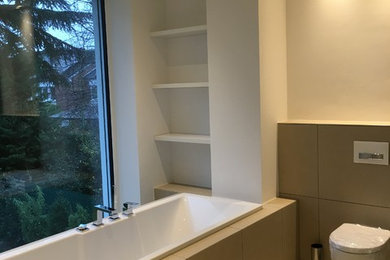 ケルンにある広いコンテンポラリースタイルのおしゃれな浴室 (ドロップイン型浴槽、バリアフリー、壁掛け式トイレ、ベージュのタイル、白い壁、セラミックタイルの床) の写真