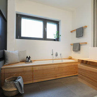 Mittelgroßes Modernes Badezimmer En Suite mit flächenbündigen Schrankfronten, hellen Holzschränken, Unterbauwanne, bodengleicher Dusche, Toilette mit Aufsatzspülkasten, grauen Fliesen, weißer Wandfarbe, Aufsatzwaschbecken, Mineralwerkstoff-Waschtisch, grauem Boden, Duschvorhang-Duschabtrennung, Doppelwaschbecken, schwebendem Waschtisch und brauner Waschtischplatte in Frankfurt am Main