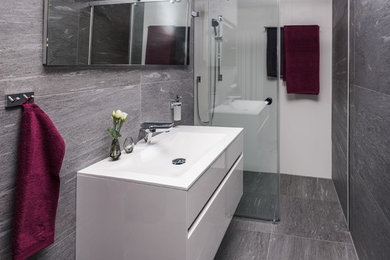 ベルリンにある小さなコンテンポラリースタイルのおしゃれなバスルーム (浴槽なし) (白いキャビネット、バリアフリー、グレーのタイル、セメントタイルの床、オーバーカウンターシンク、グレーの床、引戸のシャワー) の写真