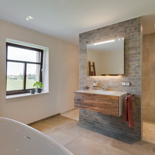 Großes Modernes Badezimmer En Suite mit flächenbündigen Schrankfronten, hellbraunen Holzschränken, freistehender Badewanne, Nasszelle, beigefarbenen Fliesen, beiger Wandfarbe, integriertem Waschbecken, beigem Boden, offener Dusche, Zementfliesen und Betonboden in Dresden