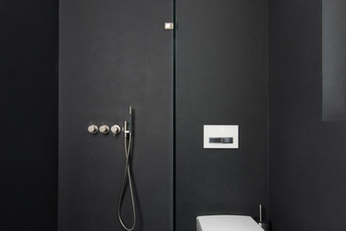 Modelo de cuarto de baño contemporáneo pequeño con sanitario de pared, paredes negras y ducha a ras de suelo