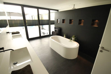 Großes Modernes Duschbad mit freistehender Badewanne, weißen Fliesen, schwarzer Wandfarbe, Betonboden und grauem Boden in Stuttgart