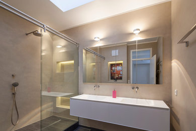 Modernes Badezimmer mit weißen Schränken, bodengleicher Dusche, beiger Wandfarbe und Trogwaschbecken in Köln