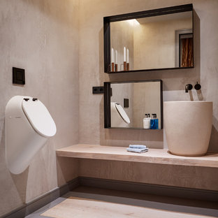 Ejemplo de cuarto de baño actual, de tamaño medio, con urinario, paredes beige, lavabo sobreencimera, suelo gris y encimeras beige