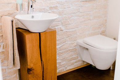 Kleines Landhaus Badezimmer mit Wandtoilette mit Spülkasten, beiger Wandfarbe, Porzellan-Bodenfliesen und braunem Boden in Nürnberg