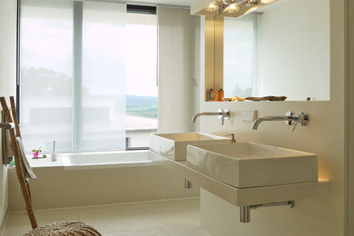 Mittelgroßes Modernes Badezimmer mit Aufsatzwaschbecken, beigen Fliesen, Porzellanfliesen, weißer Wandfarbe, Porzellan-Bodenfliesen und Einbaubadewanne in Hannover