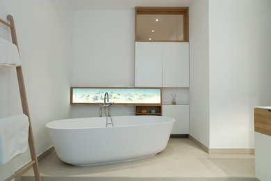 Großes Modernes Badezimmer mit flächenbündigen Schrankfronten, weißen Schränken, freistehender Badewanne und weißer Wandfarbe in Hamburg