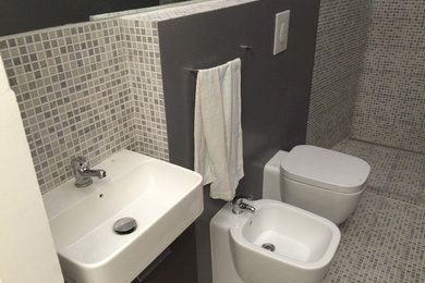 Kleines Modernes Duschbad mit offener Dusche, Bidet, grauen Fliesen, Keramikfliesen, grauer Wandfarbe, Mosaik-Bodenfliesen und Waschtischkonsole in Rom