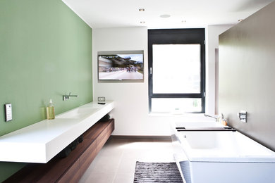 Modernes Badezimmer mit braunen Schränken, Einbaubadewanne, weißer Wandfarbe, Aufsatzwaschbecken und Waschtisch aus Holz in Düsseldorf