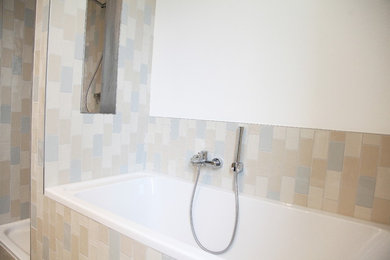 Kleines Modernes Badezimmer En Suite mit Einbaubadewanne, Nasszelle, farbigen Fliesen, Keramikfliesen, weißer Wandfarbe, Wandwaschbecken, braunem Boden und Falttür-Duschabtrennung in Sonstige