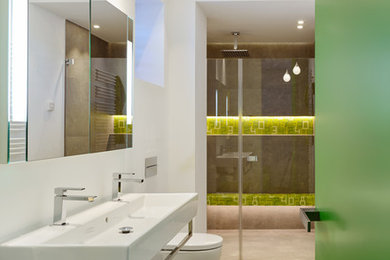 Mittelgroßes Modernes Kinderbad mit grünen Schränken, bodengleicher Dusche, Wandtoilette, grauen Fliesen, weißer Wandfarbe, Keramikboden und grauem Boden in Köln