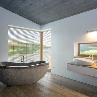 Inspiration for a large contemporary medium tone wood floor, brown floor, single-sink and shiplap ceiling freestanding bathtub remodel in Munich with flat-panel cabinets, white cabinets, white walls, a vessel sink, wood countertops, brown countertops and a floating vanity