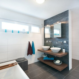 Mittelgroßes Modernes Duschbad mit offenen Schränken, freistehender Badewanne, schwarzen Fliesen, Steinfliesen, weißer Wandfarbe, Aufsatzwaschbecken, Waschtisch aus Holz, schwarzem Boden, offener Dusche, brauner Waschtischplatte, bodengleicher Dusche und Keramikboden in Stuttgart