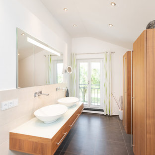 Kleines Modernes Badezimmer En Suite mit flächenbündigen Schrankfronten, hellbraunen Holzschränken, beigefarbenen Fliesen, Keramikfliesen, weißer Wandfarbe, Porzellan-Bodenfliesen, Aufsatzwaschbecken, Waschtisch aus Holz, grauem Boden und weißer Waschtischplatte in Nürnberg