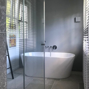 Esempio di una stanza da bagno con doccia moderna di medie dimensioni con vasca freestanding, doccia a filo pavimento, pareti grigie, pavimento grigio e porta doccia scorrevole