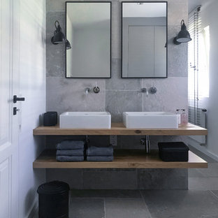 Kleines Modernes Badezimmer mit freistehender Badewanne, bodengleicher Dusche, Wandtoilette, grauen Fliesen, Aufsatzwaschbecken, grauem Boden, offenen Schränken, hellen Holzschränken, weißer Wandfarbe und Waschtisch aus Holz in Frankfurt am Main