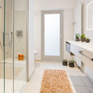 Kleines Modernes Duschbad mit flächenbündigen Schrankfronten, beigefarbenen Fliesen, weißer Wandfarbe, beigem Boden, Schiebetür-Duschabtrennung, Wandtoilette, braunen Schränken, bodengleicher Dusche, Keramikfliesen, Keramikboden, Waschtischkonsole und Mineralwerkstoff-Waschtisch in Köln